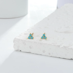 Detailed macro view of S925 sterling silver triangle stud earrings featuring turquoise stones