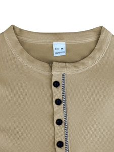 Detail of Henley neckline with black buttons on a khaki polo shirt in 100% polyester