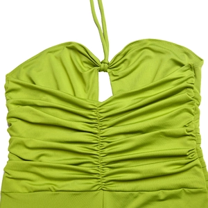 Detail view of the green halter neck top featuring dense pleats and textured elastic fabric