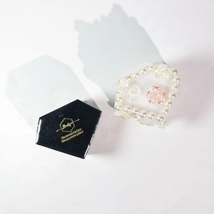 Detail of heart-shaped pearl ring organizer with resin roses in a black diamond box