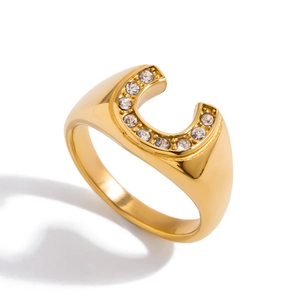Close-up of golden horseshoe-shaped titanium steel ring with sparkling zircon inlays