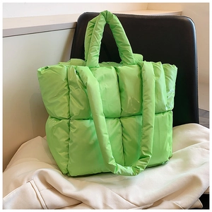 Detail of soft neon green quilted tote bag showing padded squares and dual strap design
