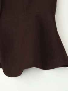 Detailed close-up showing the dark brown twill fabric texture and draped folds of the top