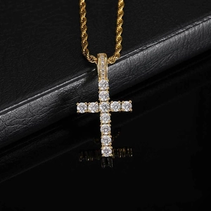 Detailed macro view of a gold plated iced out cross pendant with sparkling zircons