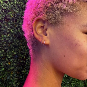 Minimalist S925 sterling silver hoop earrings worn by model with vibrant lighting