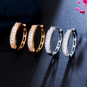 Elegant gold and silver hoop earrings with baguette cubic zirconia on black background