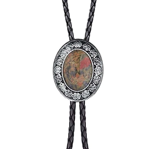 Detail of western bolo tie with patterned agate gemstone set in engraved silver metal base