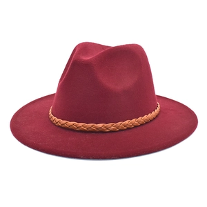 Close-up of burgundy wool fedora hat featuring a brown woven faux leather band detail