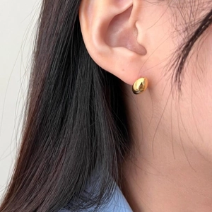 Detailed close-up of golden bean-shaped S925 sterling silver stud earrings on ear