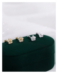 Macro detail of S925 sterling silver flower earrings with screw back on green velvet box