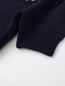 Detailed close-up of navy blue ribbed knit texture and white crochet lace hem trim