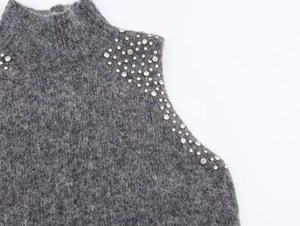 Detailed macro view of grey mohair knit top with intricate rhinestone beadwork on shoulder