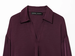 Vue détaillée du col d'une chemise en satin violet foncé avec texture de soie