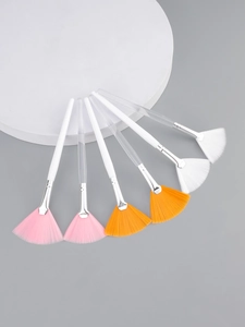 Detailed macro view of professional fan-shaped skincare brushes with soft synthetic bristles