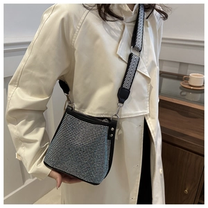 Detail of rhinestone bucket bag with black and white herringbone wide fabric strap