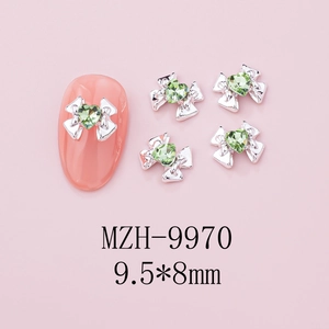 Macro detail of 9.5x8mm bow nail charm with green heart zircon and silver alloy base