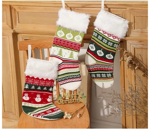 Dettaglio di calze di Natale in maglia con bordo in ecopelliccia e motivi di fiocchi di neve