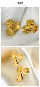 Detail view of gold flower earrings with brushed texture, zircon and pearl accents