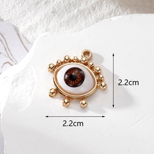 Detailed view of evil eye jewelry pendant measuring 2.2cm on white marble background