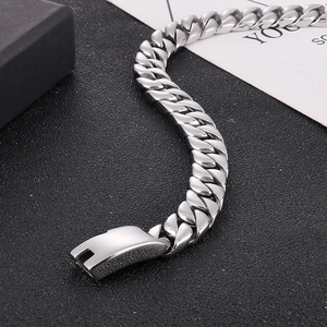Detail of 12mm silver Cuban link chain with a secure clasp on black textured background