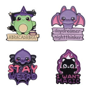 Set of four magical enamel pins featuring fantasy frog, bat, cat, and spider web designs