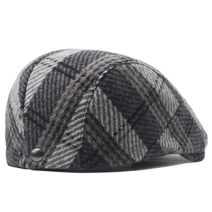 Detail view of the tweed plaid pattern and metal snap adjustment on the winter beret