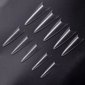 Vista macro di dieci diverse misure di unghie finte a stiletto trasparenti per saloni