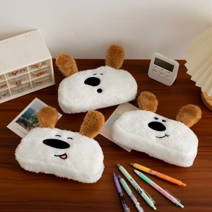 Detailed view of three cute plush dog pencil cases with soft white fur and various facial expressions
