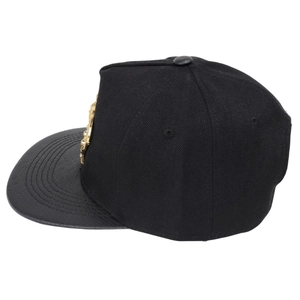 Detail of flat brim snapback with gold crown metal logo and snake skin texture
