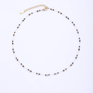 Detailed macro view of gold plated chain necklace with integrated black bead accents