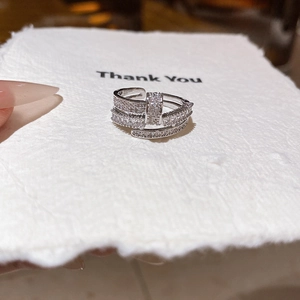 Macro shot of a layered silver-tone ring with sparkling zircon pavé on a thank you card