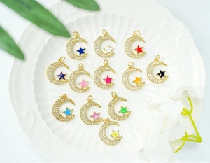 Macro shot of 12 color moon and star charms with micro-pave cubic zirconia on ceramic tray
