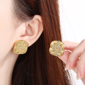 Detailed view of 18K gold plated square earrings with woven texture and crystals