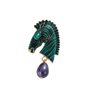 Vintage zebra head brooch with green enamel, gold trim, and a black pearl drop pendant