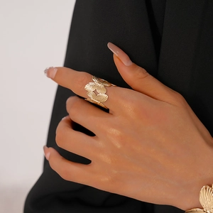 Detail of golden butterfly ring with brushed metal texture on female hand