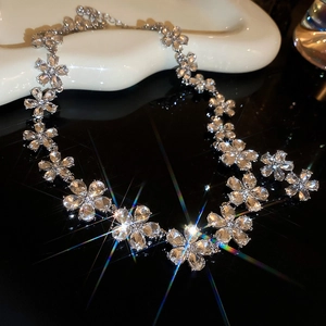 Close-up of silver floral necklace with sparkling crystals and rainbow light reflections
