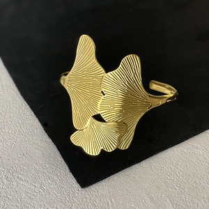 Macro detail of golden gingko leaf texture and layered pattern on stainless steel cuff