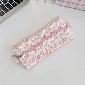 Close-up of pink quilted pencil case featuring lace edges and cute rabbit patterns