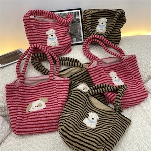 Close-up of cute puppy embroidery on striped plush tote bags in various colors