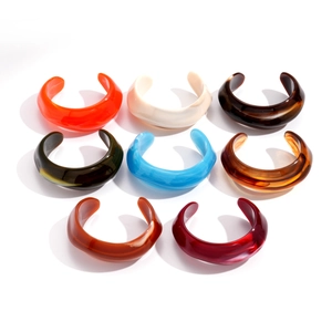 Minimalist geometric acrylic open bangles in various marbled colors on white background