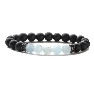 Detail of matte black beads and blue faceted stones on a stretch beaded bracelet