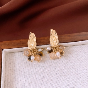 Detail of vintage style tassel earrings with pearls and gemstones on linen tray