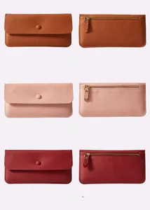Dettagli dei portafogli a busta in pelle marrone, rosa e rosso con cerniere in oro