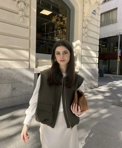 Detailed view of women's olive green oversized vest with zipper and large pockets