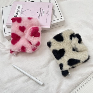 Close-up of soft faux fur coin pouches featuring red and black heart patterns in detail