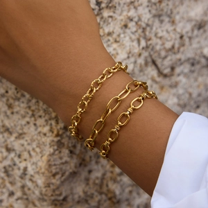 Close-up of three layered 18k gold plated stainless steel paperclip and link bracelets