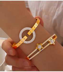 Close-up of gold-plated geometric bracelets featuring sparkling star and zircon pavé detail