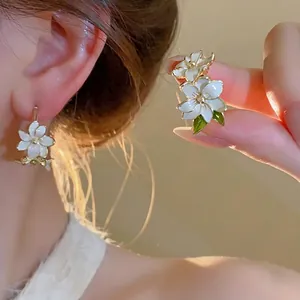 Elegant white oil-dripped flower stud earrings with gold edges and green leaves for women