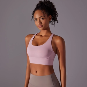 Dettaglio del reggiseno sportivo rosa con spalline incrociate e tessuto spazzolato traspirante