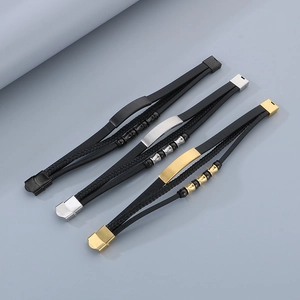 Detailed close-up of woven leather bracelets with silver, gold, and black metal plates